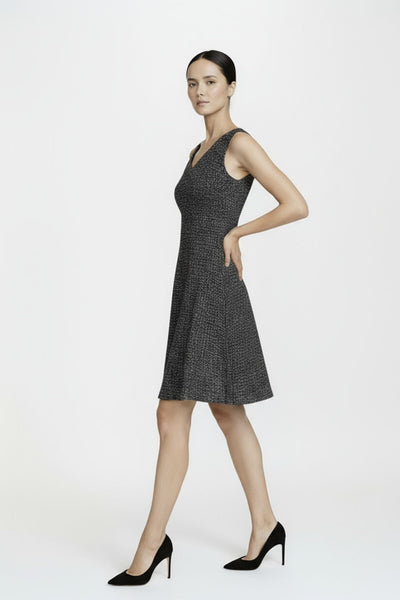 Woman wearing a black and white patterned dress on a white background