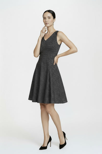 Woman wearing a black patterned dress on a white background