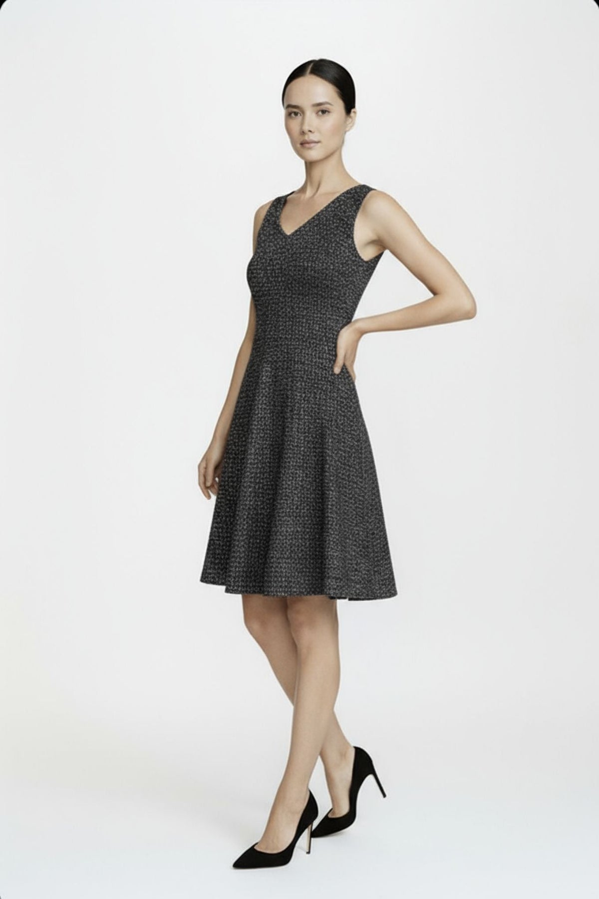 Woman wearing a black patterned dress on a white background